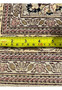 Backside closeup with ruler measuring knot density of handmade Agra wool rug highlighting weave detail, craftsmanship, and construction quality