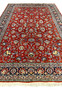 Top down view Tabriz rug red background ivory and blue flowers navy border fine weave botanical layout.