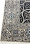 Side view showing low dense pile of Persian Nain 6 LA Kork wool rug with silk floral highlights navy dome pattern.