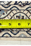 Back of Persian Nain 6 LA Habibian rug with measuring tape displaying tight knots ivory cotton base and precise weaving.