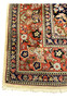 Coral red border detail of Persian Bijar rug with repeating floral clusters navy outlines and ivory guard bands