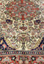 Detailed floral motifs on Persian Bijar rug with coral medallion ivory ground navy accents and intricate vine work