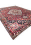 Perspective view of vintage Persian Bakhtiari area rug 10x14 with red field and ivory center medallion.