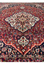 Midfield detail of vintage Persian Bakhtiari rug showing dense hand-knotted floral pattern on crimson ground