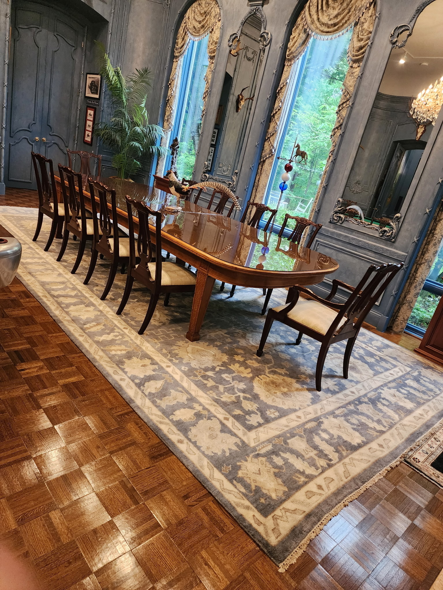 Customer dining room with a soft-toned Chobi Peshawar rug under a wooden table, muted vegetable-dyed colors