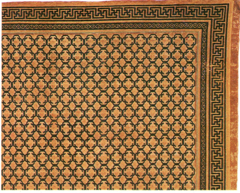 Detail of an 18th century Chinese rug with geometric bracket pattern forming an interlocked curvilinear lattice