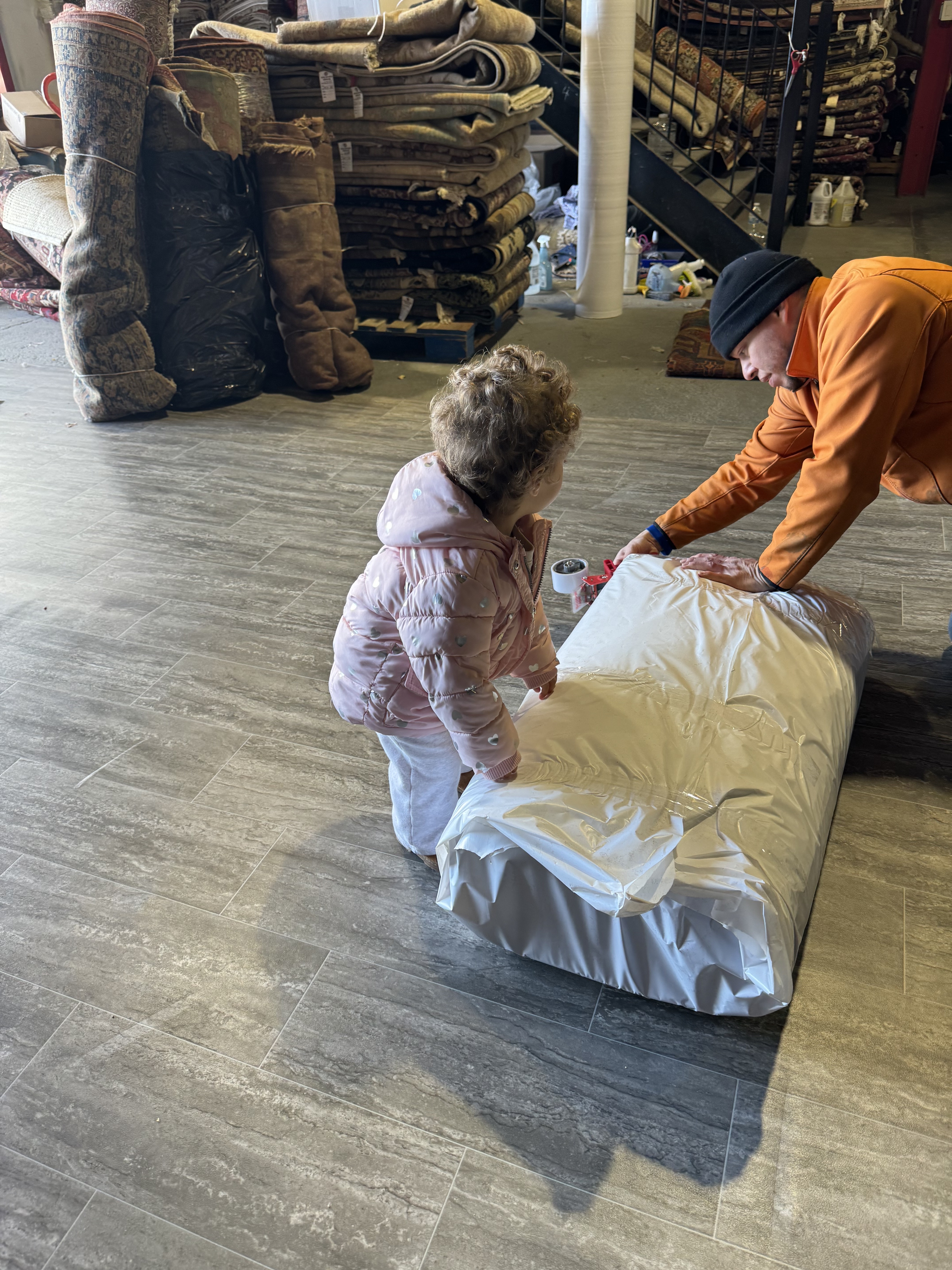 The next generation helping pack a rug at the Rugs.net family warehouse in Freeport, NY