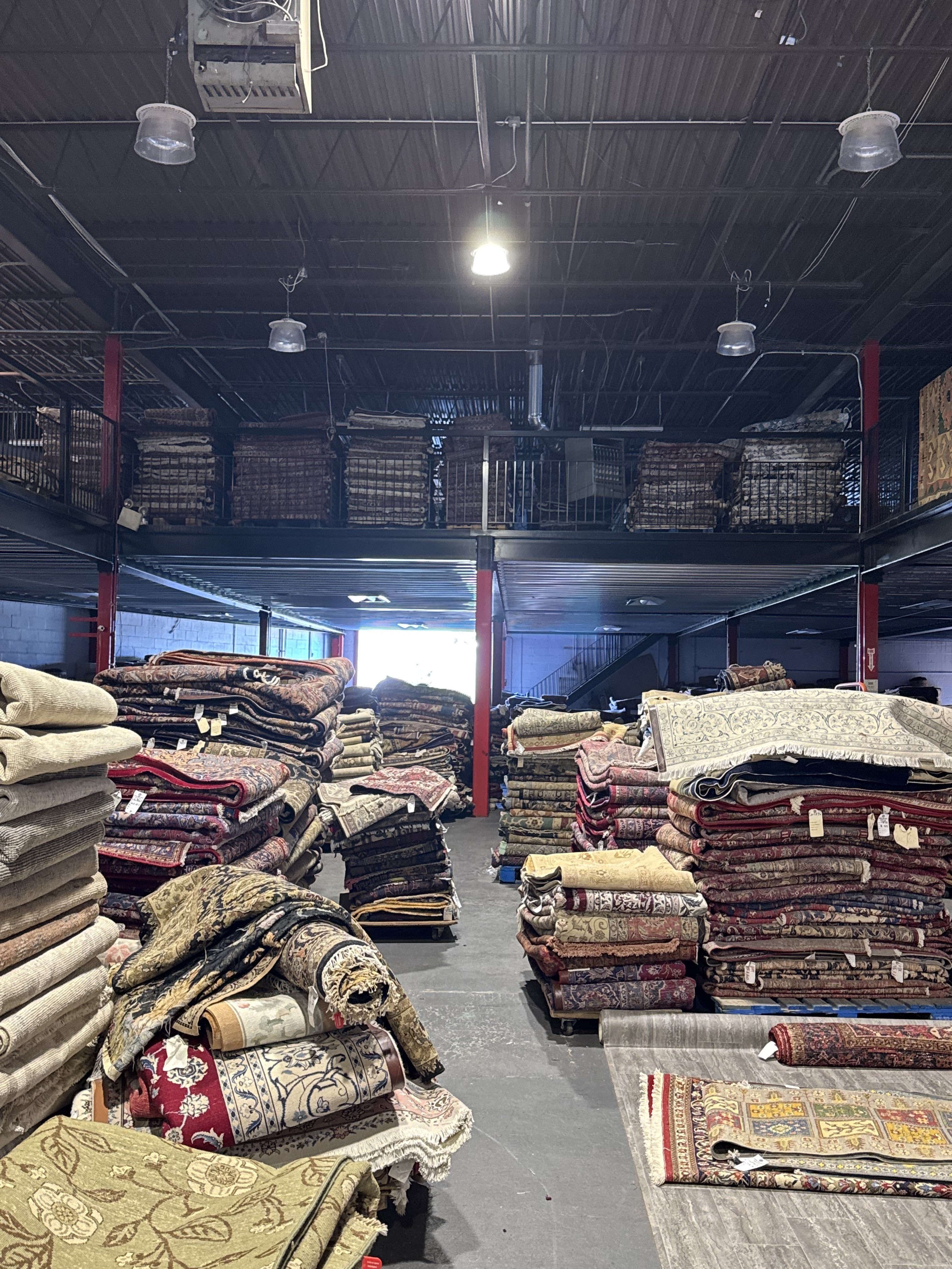 Inside the Rugs.net warehouse in Freeport New York, aisles of rolled handmade rugs stacked floor to ceiling