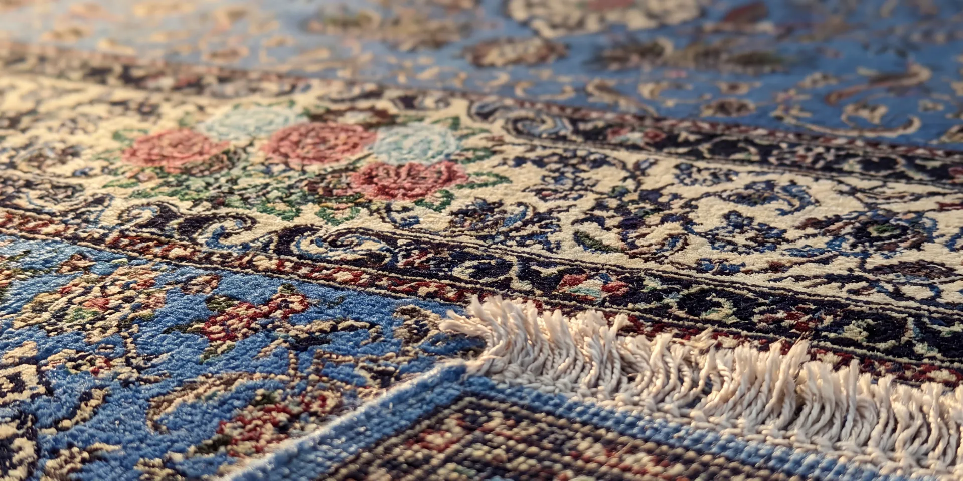 Macro view of the knotted pile and silk fringe of a Persian Isfahan rug