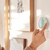 Person adjusting nest thermostat temperature on the wall