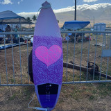 Surfboard with a purple and pink heart design made with Sticky Bumps' Bright Bars colored surf wax. Surfboard with a purple and pink heart design made with Sticky Bumps' Bright Bars colored surf wax.