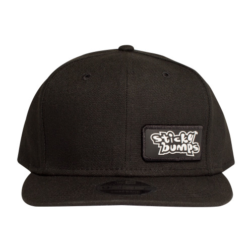 Front view of the black New Era snap back hat with a sewn on white and black Sticky Bumps logo patch.