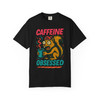 Black short-sleeve tee showcasing the “Caffeine Obsessed” squirrel illustration, with red and teal text popping against the dark background.