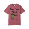 Brew First, Think Later – Bert’s Morning Motto Tee by Coo Coo’s Coffee in crimson red, bold coffee humor shirt with gecko mascot.