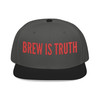 Black/Charcoal Gray/Charcoal Gray Snapback Hat – Brew Is Truth embroidery in bold red on a two-tone black and charcoal snapback, bold coffee lifestyle hat by Coo Coo’s Coffee.