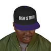 Person wearing a Brew Is Truth black and purple snapback hat looking down