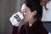 Woman sipping from SBOF monogram coffee mug with Small Batch of Friends text