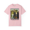 The Americano Gothic coffee tee — two geckos posed as the couple from Grant Wood's American Gothic in front of a white gothic-window farmhouse; Bert in sunglasses holding a pitchfork, Gertie in pearls beside him, with "The Americano Gothic" and a red Florida Brew Crew line beneath — Coo Coo's Coffee Brew Good Vibes garment-dyed Comfort Colors art parody tee.