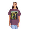 The Americano Gothic coffee tee — two geckos posed as the couple from Grant Wood's American Gothic in front of a white gothic-window farmhouse; Bert in sunglasses holding a pitchfork, Gertie in pearls beside him, with "The Americano Gothic" and a red Florida Brew Crew line beneath — Coo Coo's Coffee Brew Good Vibes garment-dyed Comfort Colors art parody tee.