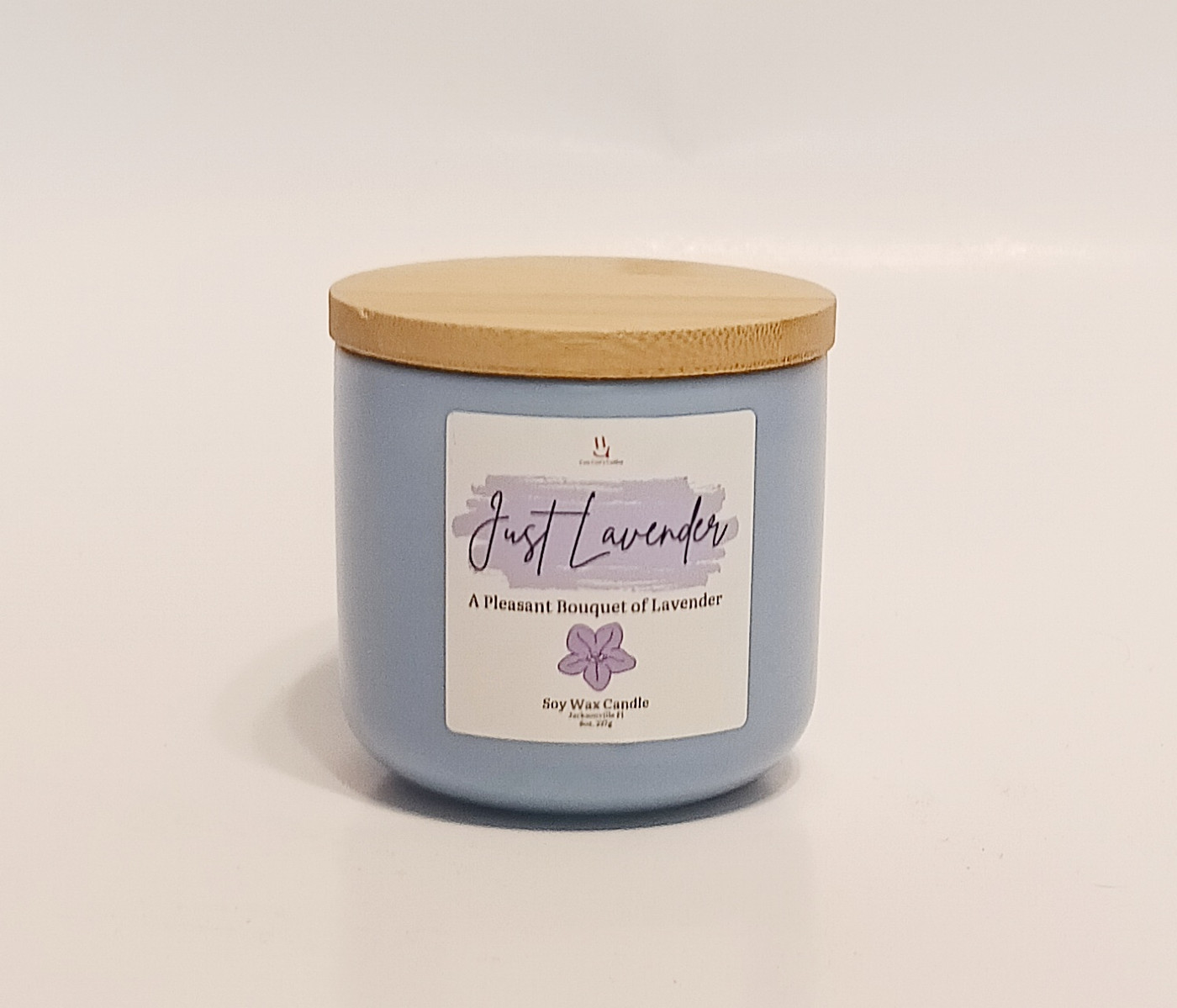 Just Lavender jar candle with purple label and soft glowing flame – Coo Coo’s Coffee