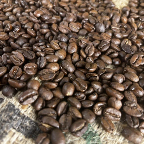 Dark roast coffee beans on a burlap bag