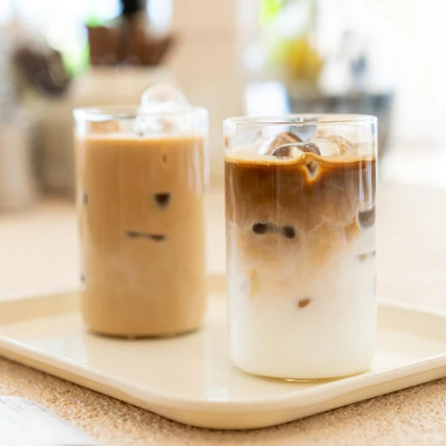 Two iced latte drinks in clear glasses on a tray, inspiration for Graham Cracker Latte wax melt scent