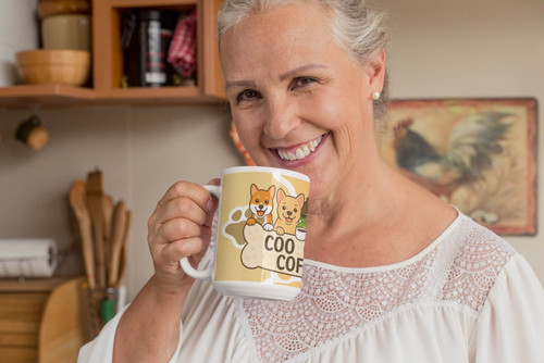 Smiling woman in kitchen holding a Coo Coo’s Coffee Paw-sitive Mornings dog bone mug