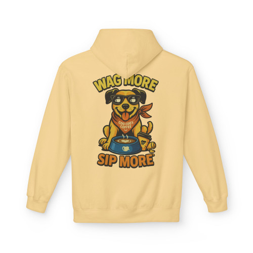 Yellow haze hoodie with “Wag More, Sip More” Coffee Pup print by Coo Coo’s Coffee, playful dog illustration with coffee bowl and cheerful brand vibe.