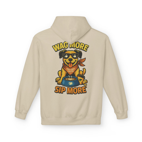 Sand color hoodie with the “Wag More, Sip More” Coffee Pup design by Coo Coo’s Coffee, featuring a happy dog in a red bandana sipping coffee.