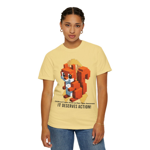 Butter yellow tee with pixel squirrel and coffee cup artwork, golden ribbon tribute, and bold “It Deserves Action” lettering – Childhood Cancer Awareness Tee by Coo Coo’s Coffee. Female Model