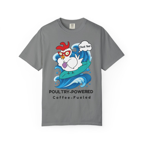 Grey Comfort Colors t-shirt with a cartoon chicken surfing and shouting “Cluck Yeah!” with the words “Poultry-Powered, Coffee-Fueled.”