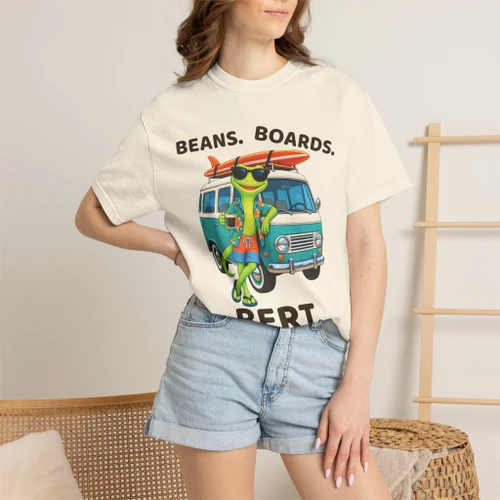 Close-up of the surf gecko Bert with a retro aqua camper van and longboard graphic print on the Beans. Boards. Bert. t-shirt, ivory