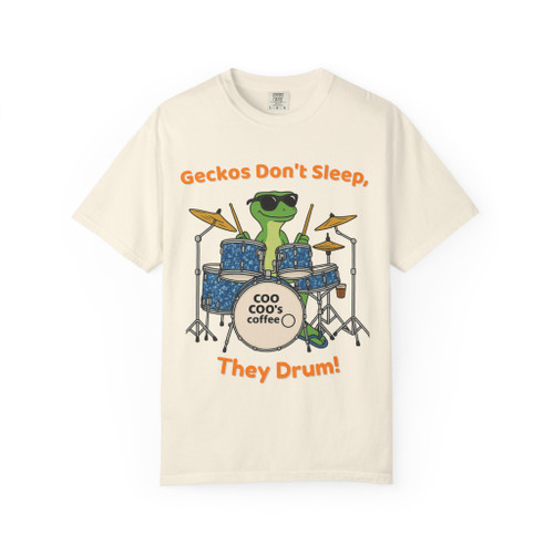 Ivory tee with gecko drummer on blue kit and “Geckos Don’t Sleep, They Drum!” text—Coo Coo’s Coffee tour vibe.
