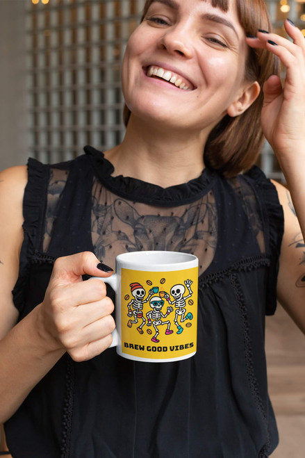 Smiling woman holding the Brew Good Vibes skeletons coffee mug in a café.