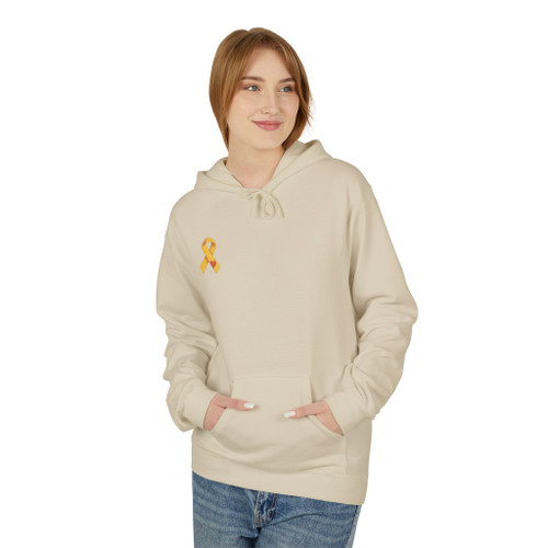 Our block-built squirrel — brave, small, and unmistakably himself — holds his gold ribbon beneath the line we believe in: from little acorns, mighty love grows.  $7 from every hoodie goes to help families facing childhood cancer. hoodie sands