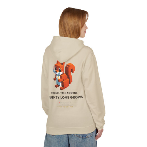 Our block-built squirrel — brave, small, and unmistakably himself — holds his gold ribbon beneath the line we believe in: from little acorns, mighty love grows.  $7 from every hoodie goes to help families facing childhood cancer. hoodie sands