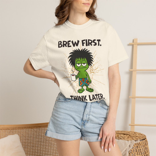 Close-up of the gecko Bert brewing, “brew first, think later” graphic print on the Brew First, Think Later t-shirt, ivory