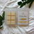 Vanilla Bean wax melt clamshell on white blanket with green leaves, cozy flatlay by Coo Coo’s Coffee