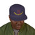 Navy blue snapback hat with red smiley face and bold yellow “Brew Is Truth” text arched below the design. Coffee lifestyle streetwear from Coo Coo’s Coffee. Male model front