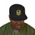 black snapback hat with embroidered Bert surfing badge and yellow bill – Coo Coo’s Coffee