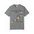 Dark charcoal bravery beads tee lying flat with colorful bead-heart design and “Every Bead Tells a Story. Help Stop The Poke.” text.