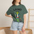 Close-up of the skateboarding gecko Bert grinding a rail with coffee graphic print on the Grind t-shirt, boue spruce female