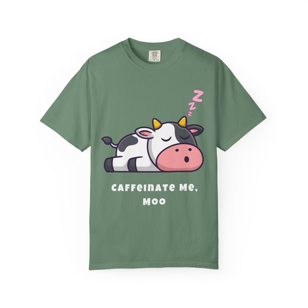 Light green tee with playful cow graphic and "Caffeinate Me, Moo" text – Funny Coffee Shirt by Coo Coo’s Coffee.