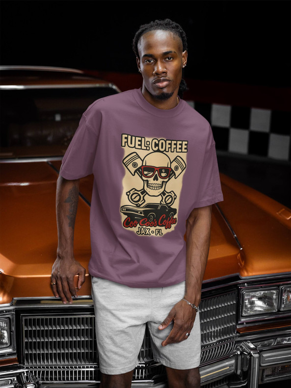 Octane Brew – Skull & Pistons Tee by Coo Coo’s Coffee in berry, modeled with classic car — skull, pistons, and coffee-fueled graphic for car lovers and coffee fans.