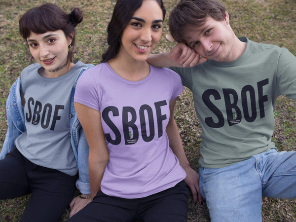 Friends sitting in SBOF tees (Violet, Blue Jean, Light Green) — cozy coffee-crew vibe — Coo Coo’s Coffee
