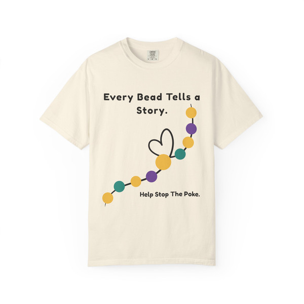 Cream bravery beads tee lying flat with “Every Bead Tells a Story. Help Stop The Poke.” and bead-heart graphic on the front.