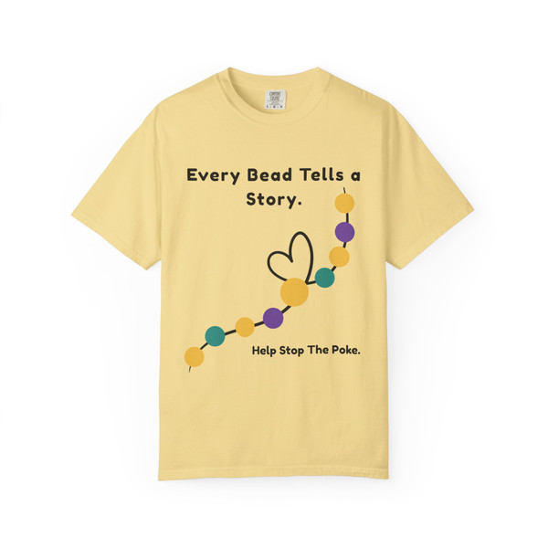 Gold-yellow bravery beads tee lying flat with “Every Bead Tells a Story. Help Stop The Poke.” and bead-heart graphic.