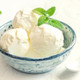Bowl of creamy white vanilla ice cream scoops with a fresh mint garnish, symbolizing the sweet vanilla notes in Vanilla Rose wax melts.