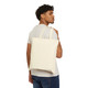 Canvas tote bag featuring Coo Coo’s Coffee’s gecko mascot Bert meditating with a yellow sun behind him and the phrase “Inner Bean, Outer Zen.” Male model