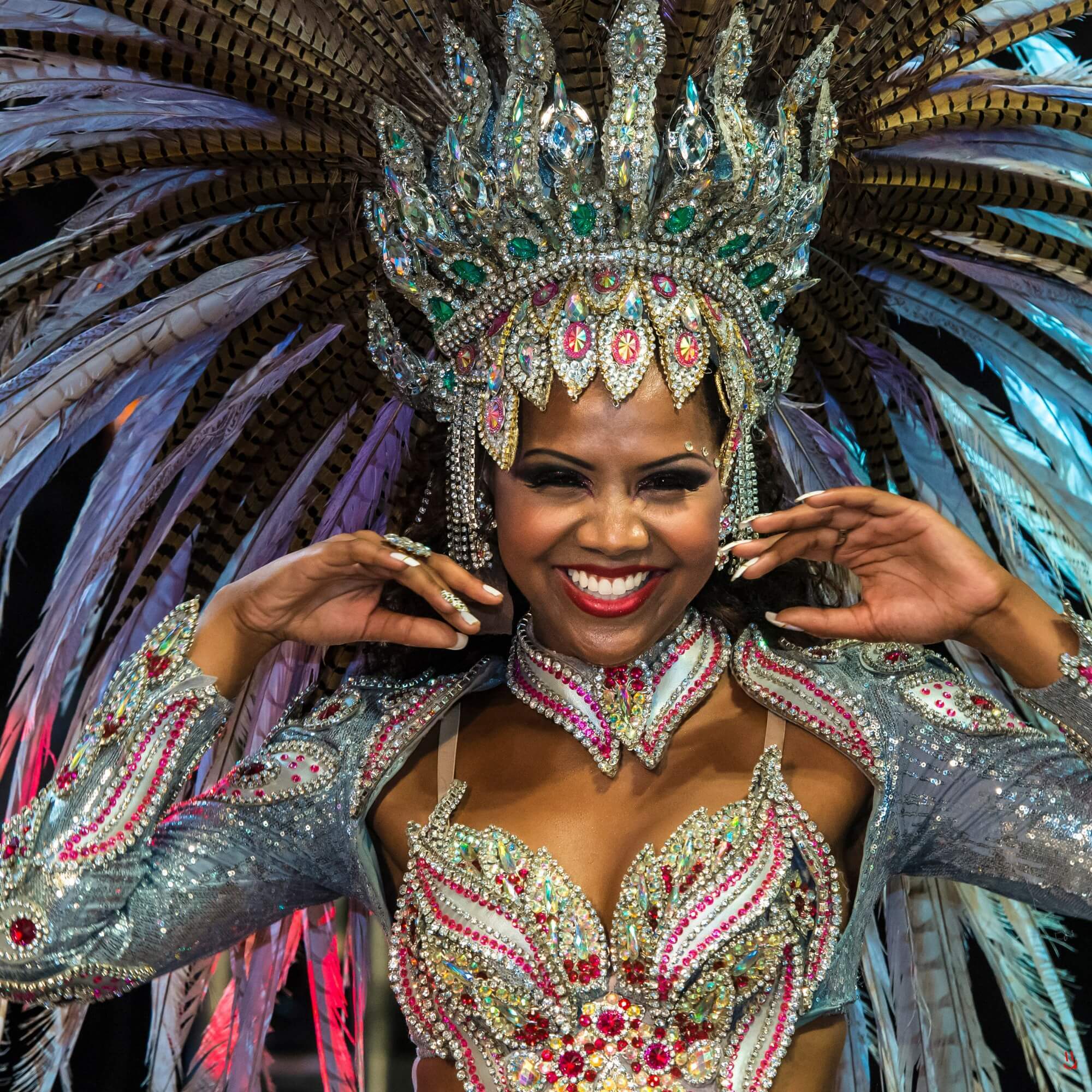 Performer in vibrant Carnival costume smiling at the camera